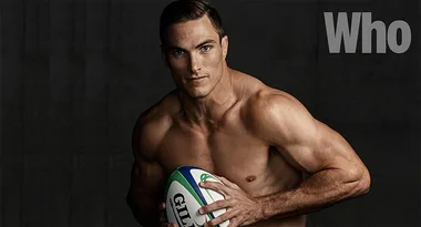 Shirtless man holding a rugby ball, with the word "Who" in large letters on the top right.