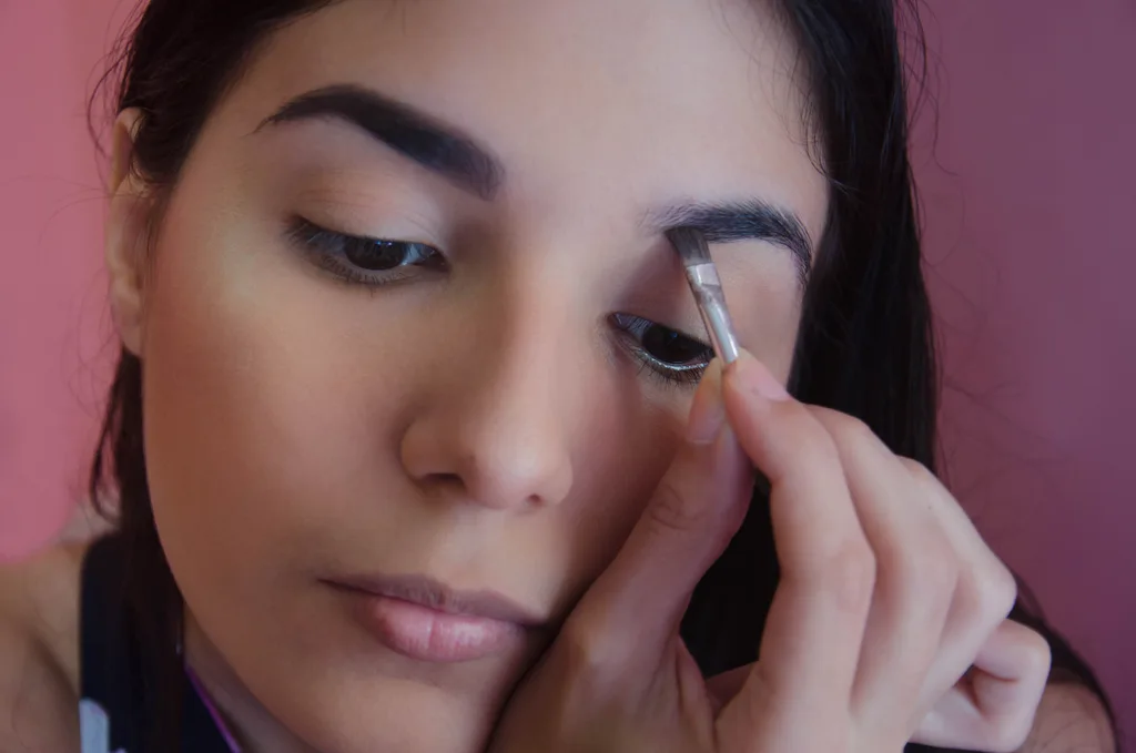 Girl filling in eyebrow