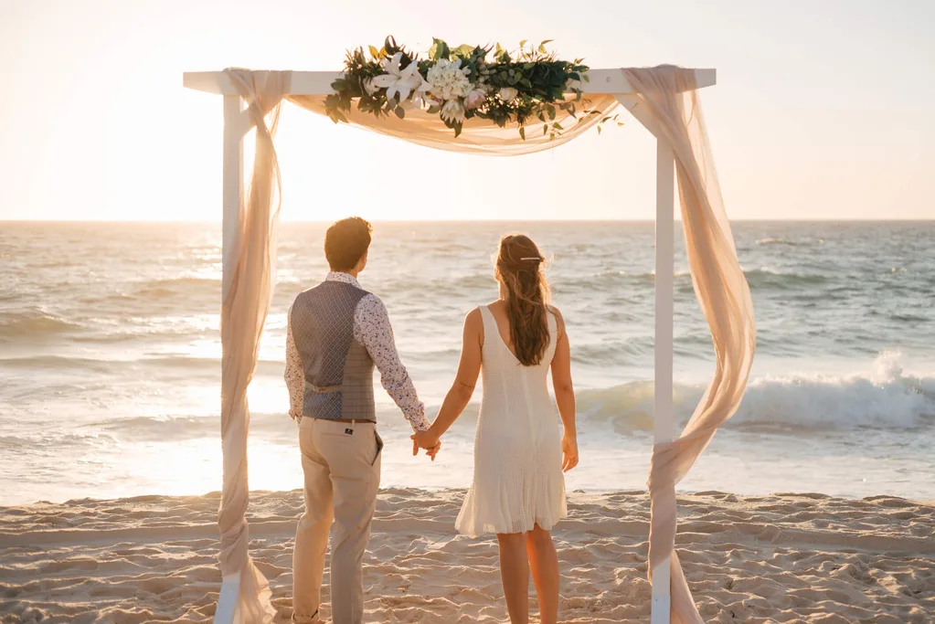 A couple getting married on the beach at sunset