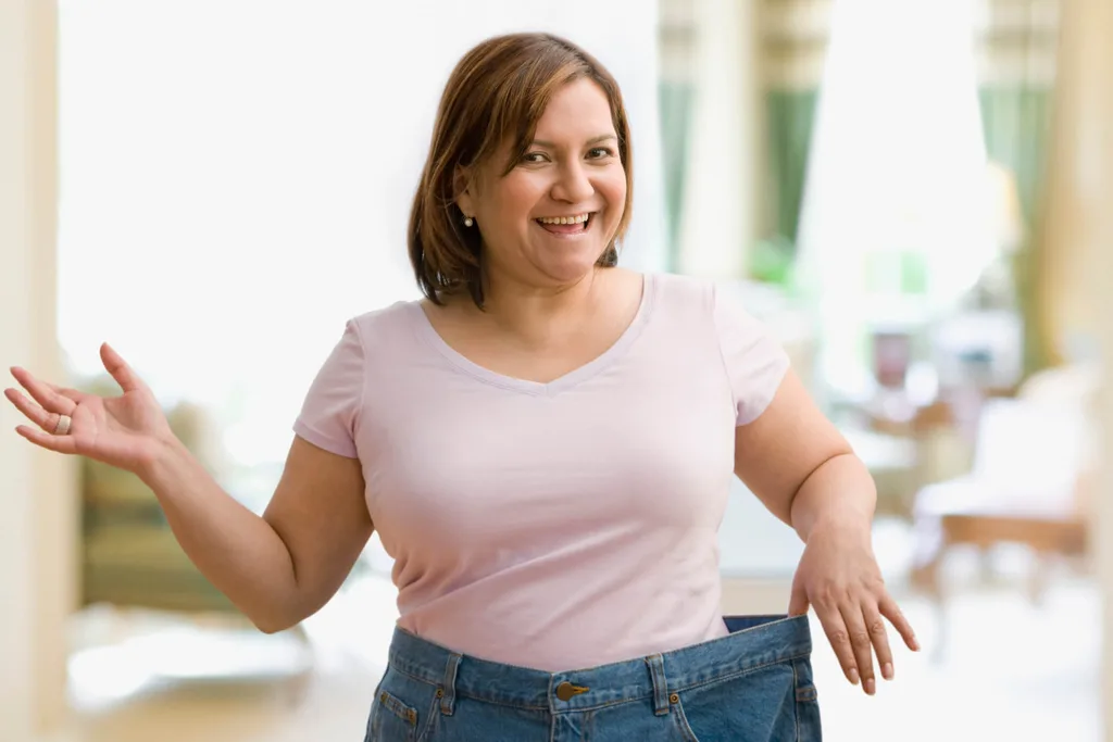 Woman holding waistbands of jeans that are too big
