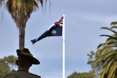 Soldier looking at an Australian flag flying in the wind