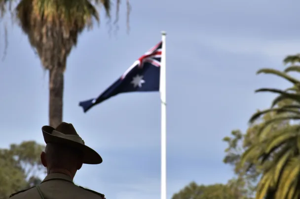 Soldier looking at an Australian flag flying in the wind