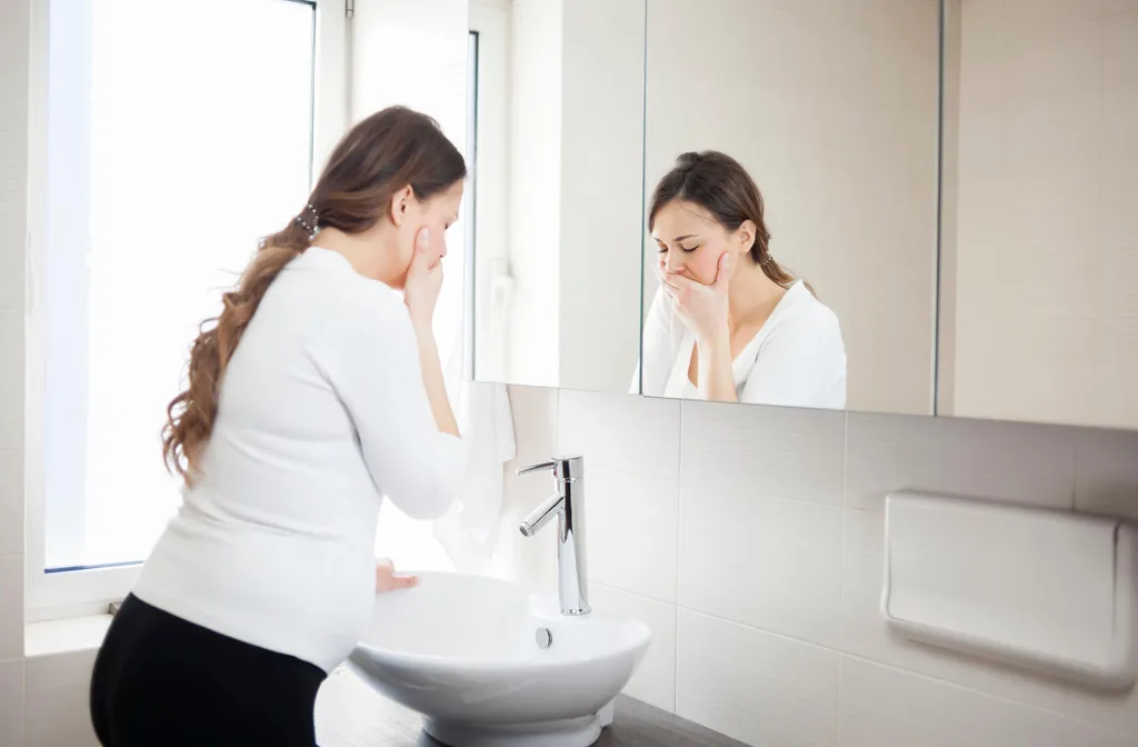 A woman with morning sickness in the bathroom