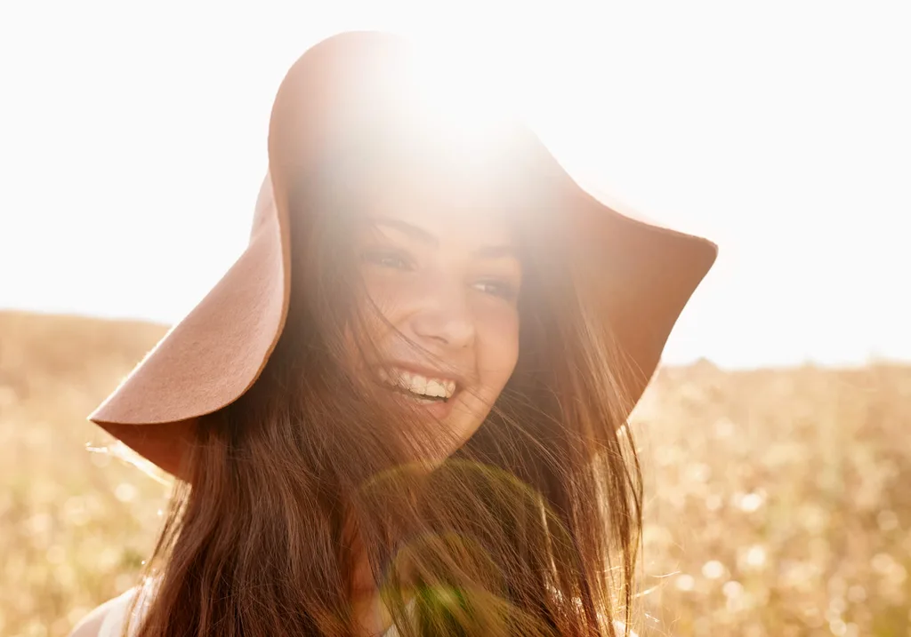 Woman standing in a golden field in the sunlight