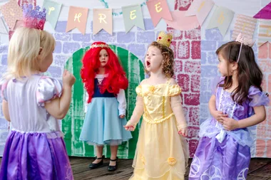 Young girls playing in a castle painting during a princess party
