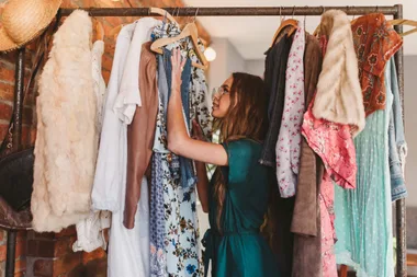 A woman looking through a rack of clothing