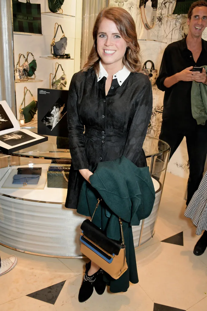 Princess Eugenie of York in a black velvet dress with a green coat