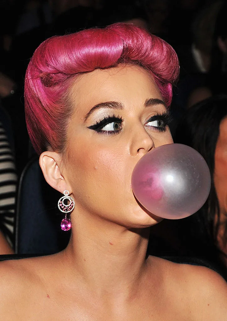 Hot pink haired Katy Perry blowing a bubble at the 2011 American Music Awards