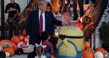 Donald Trump unsure how to give a child dressed as minion Halloween lollies
