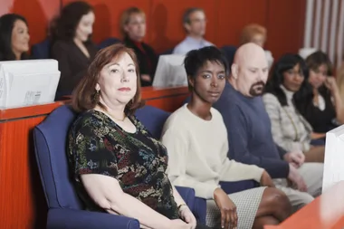 A jury seated in blue sofas chairs