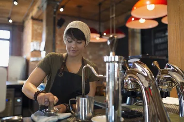 A barista making coffee in a cafe