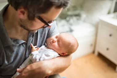 A father holding a young baby