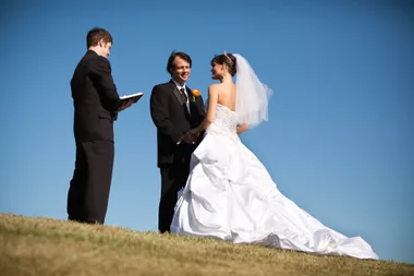 A marriage celebrant reading the vows to a couple