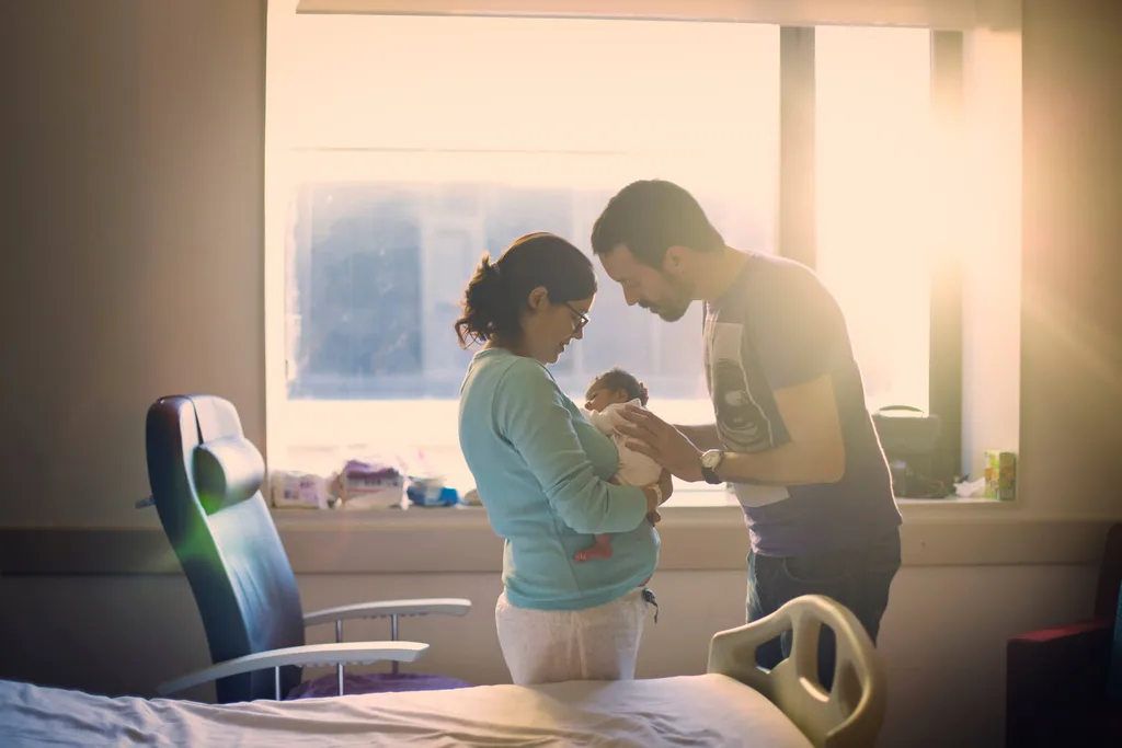 Parents holding a baby in a hospital room