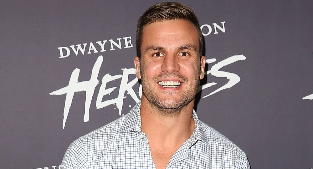 Man smiling at the "Hercules" premiere event against a branded backdrop.
