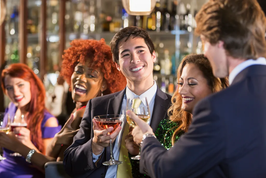 A businessman in a suit with friends at a bar