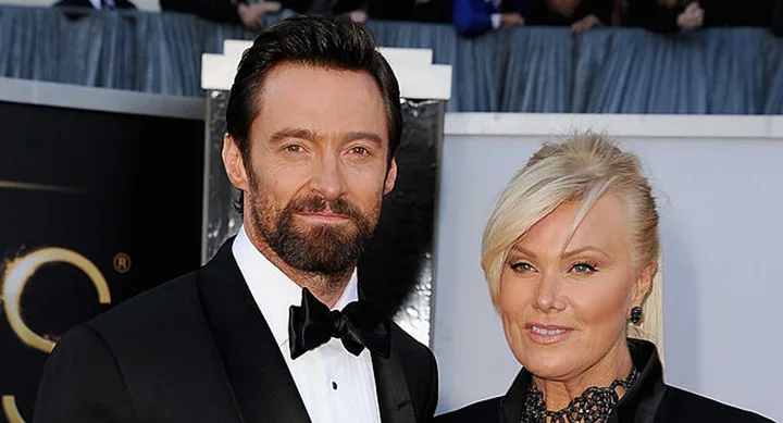 Two individuals dressed elegantly, posing together on a red carpet event.
