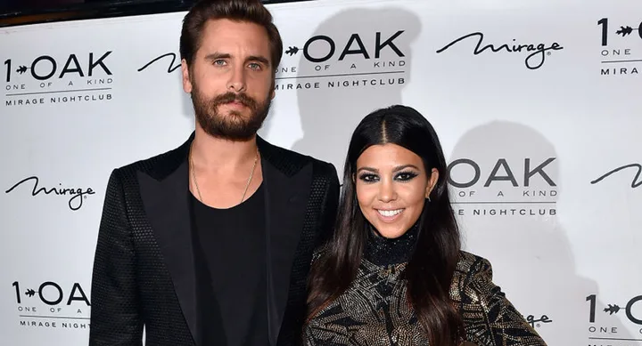 Two people smiling at an event with a 1 OAK Mirage nightclub backdrop.