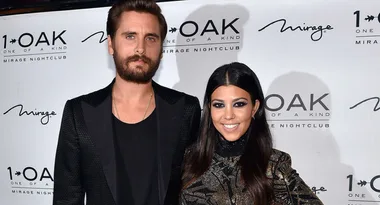 Two people smiling at an event with a 1 OAK Mirage nightclub backdrop.