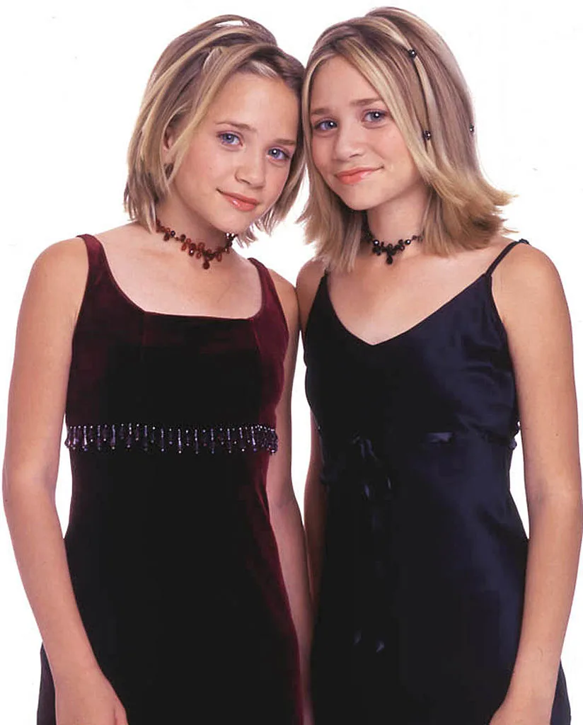 Mary-Kate and Ashley Olsen posing in velvet dresses