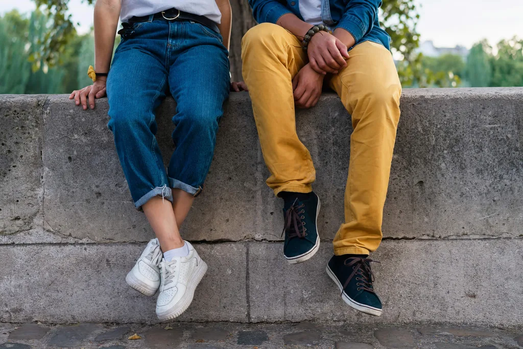 Two people sitting on a brick wall