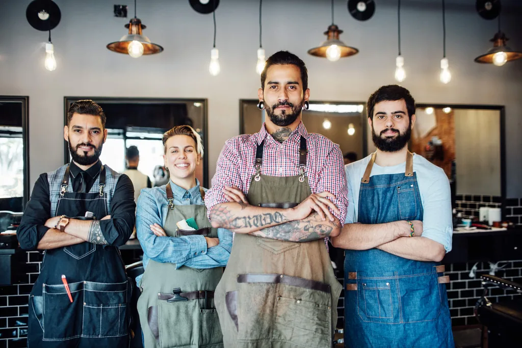 Four hairdressers crossing their arms in a hairdressing studio