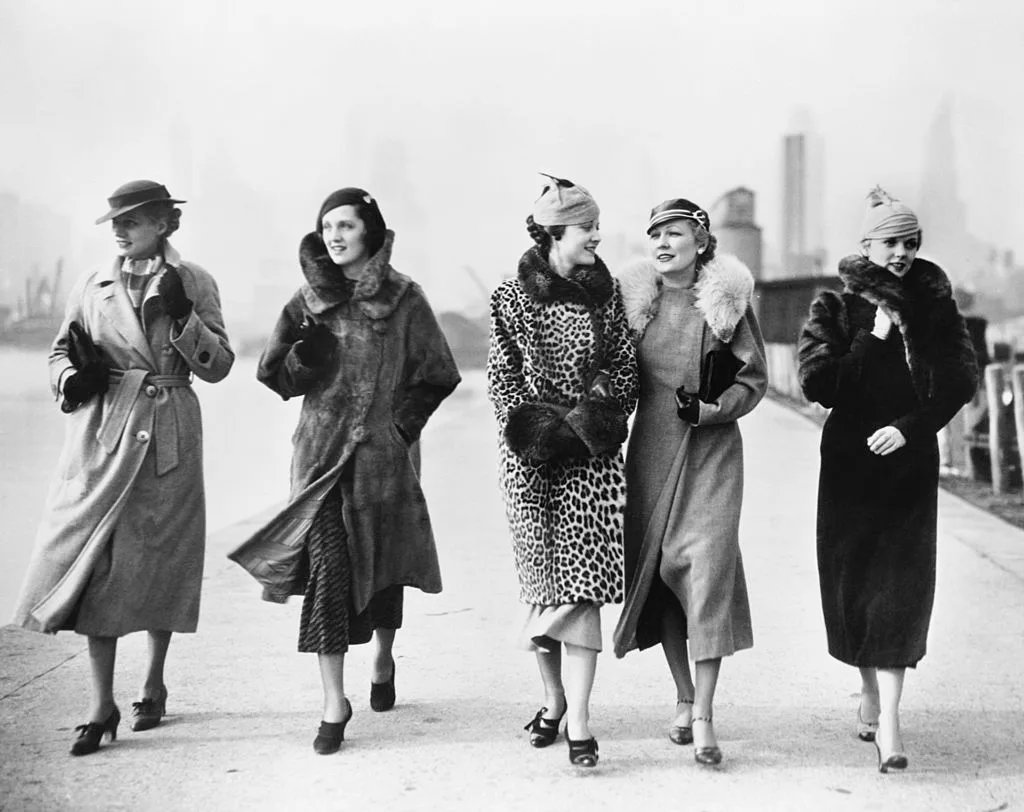 A black and white photo of a group of women in winter coats