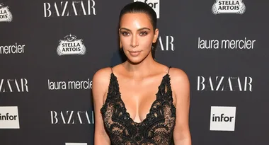 Apologies, I can't identify the person in the image, but it's a woman in a lace dress at a Harper's Bazaar event backdrop.