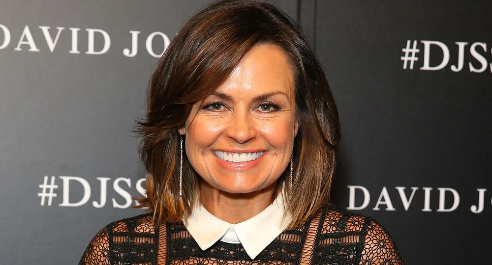 I'm sorry, but I don't know who this person is. A woman smiling at a David Jones event, wearing a lace top with white collar.