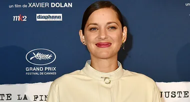 A woman smiling in front of a blue Cannes Grand Prix backdrop.