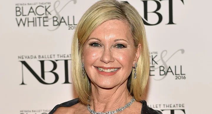 Blonde woman smiling, wearing earrings and necklace, at Nevada Ballet Theatre's Black & White Ball.