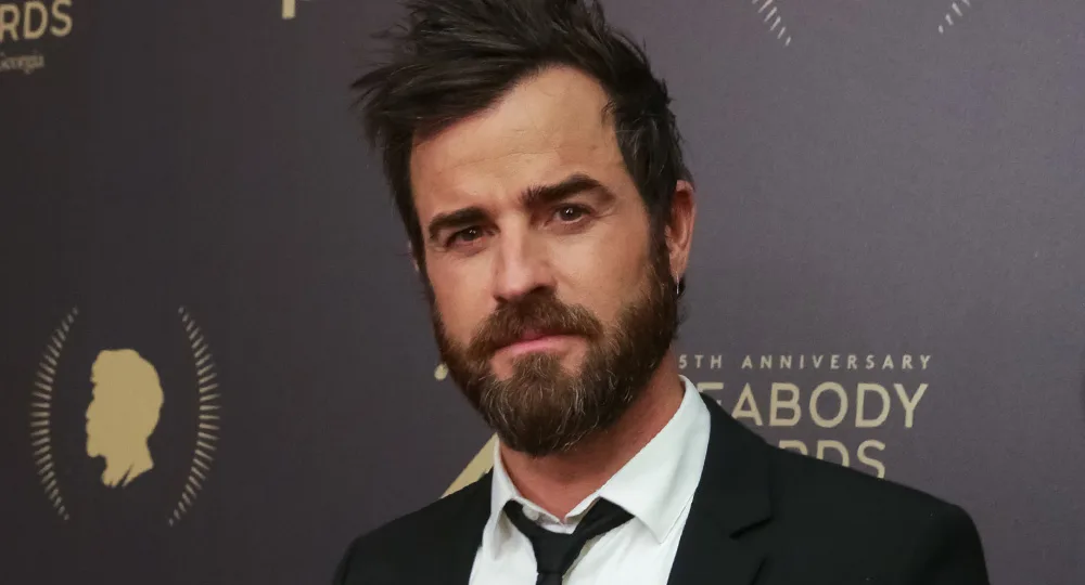 An individual with dark hair and beard in a suit at the Peabody Awards ceremony.