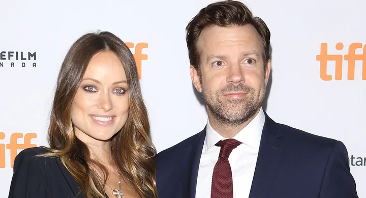 Two people smiling together on the TIFF red carpet, dressed in formal attire.