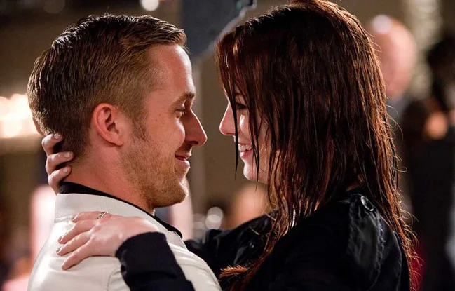 ```plaintext
Man and woman smiling at each other in an embrace, indoors.
```