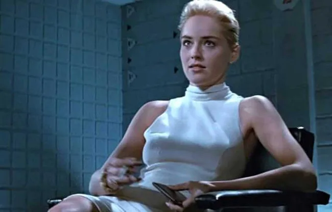 Woman in a white dress sitting on a chair, scene from a movie, in a blue-tiled room.