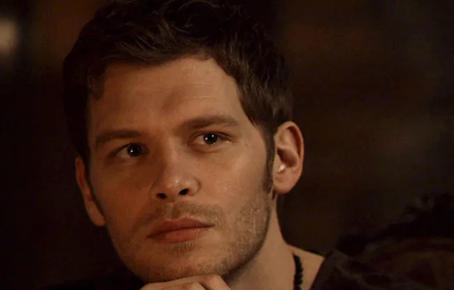 A character from "The Originals" series, staring pensively with a dark background.