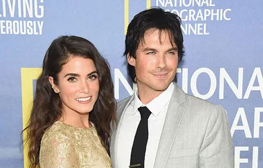 A smiling couple poses at an event with a National Geographic Channel backdrop.
