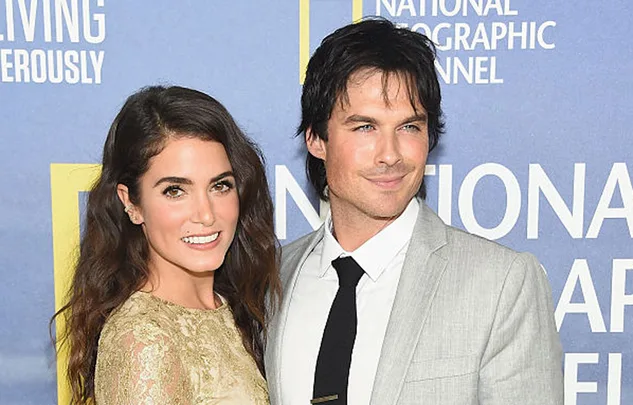 A smiling couple poses at an event with a National Geographic Channel backdrop.