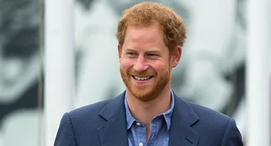 A smiling man with red hair and a beard wearing a blue blazer and shirt.