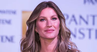 A woman with long hair at a Pantene event, smiling softly.
