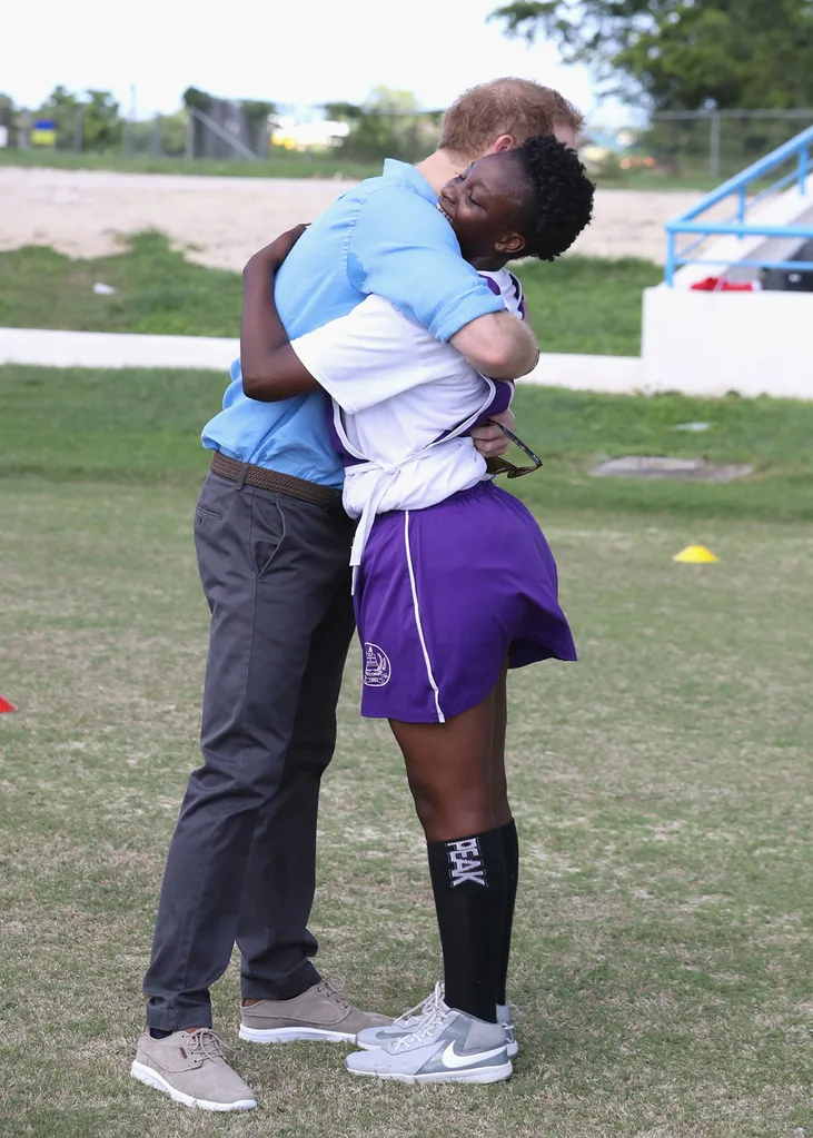 Prince Harry hugs Harmony Edwards, aged 14 as he attends a youth sports festival at Sir Vivian Richards Stadium showcasing Antigua and Barbuda's national sports, on the second day of an official visit to the Caribbean on November 21, 2016 in Antigua, Antigua and Barbuda.