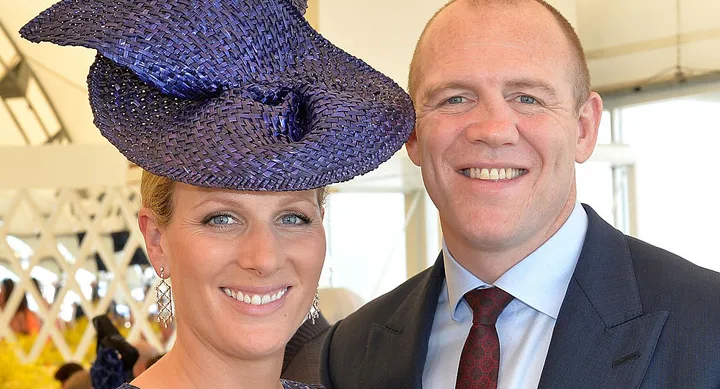 Two people posing together; the woman is wearing a purple hat, and both are smiling.