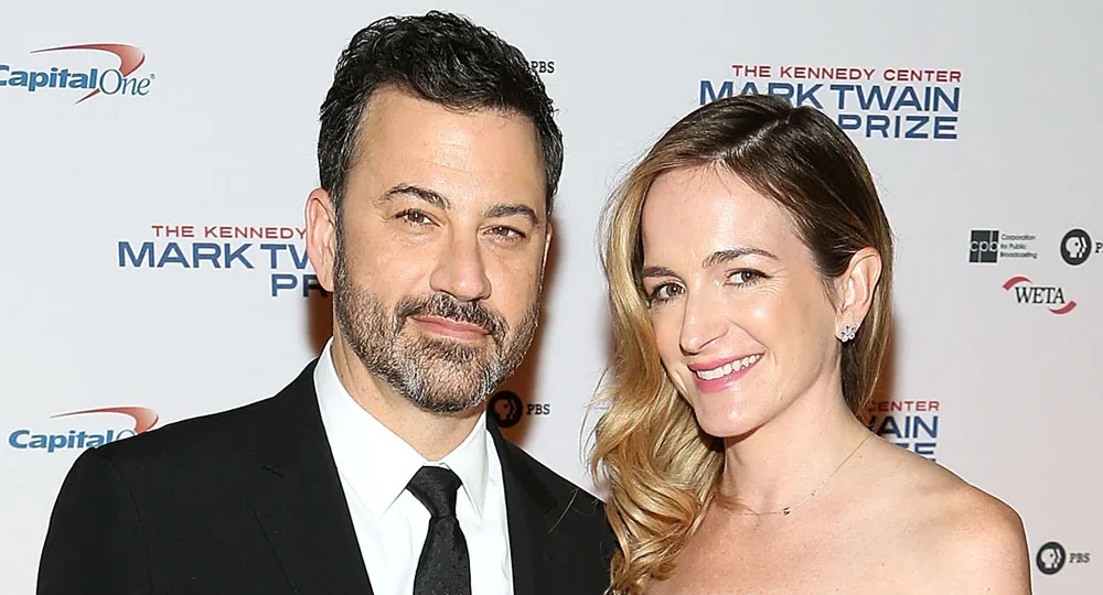 Two people smiling at the Mark Twain Prize event, standing in front of a branded backdrop.