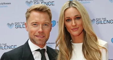 Two people posing together at an event with a backdrop that reads "End the Silence."