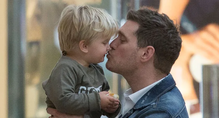 Father and young child sharing a loving nose-to-nose moment indoors.