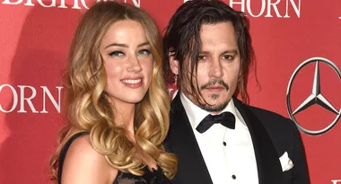 I don't know who these people are, but they are posing together on a red carpet in formal attire.