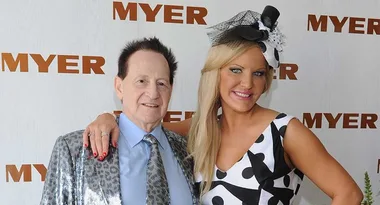 Two people posing at a Myer event; one in a leopard-print jacket, the other in a polka-dot dress with a large hat.