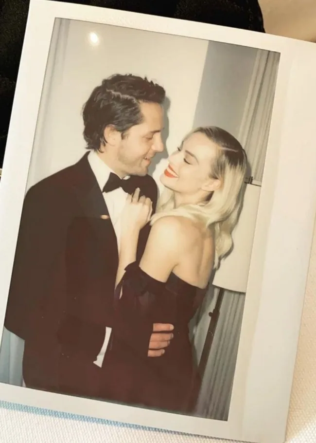 Margot Robbie and husband Tom Ackerley posing for a polaroid
