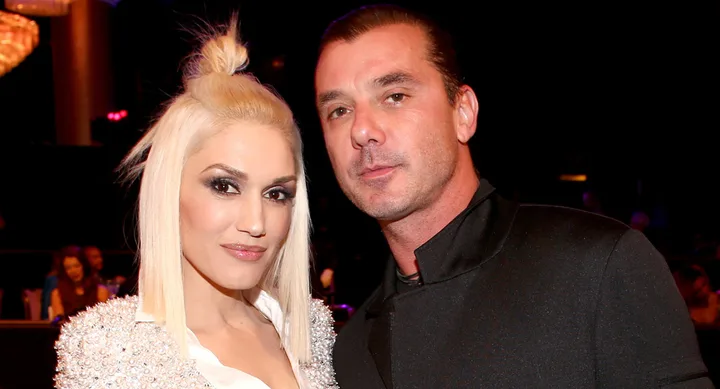 A woman with blonde hair and a man with dark hair pose together in formal attire at an indoor event.