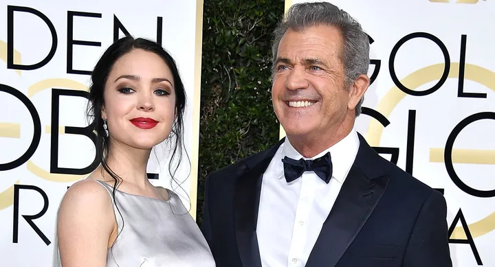 Two people in formal attire pose together at the Golden Globes event.